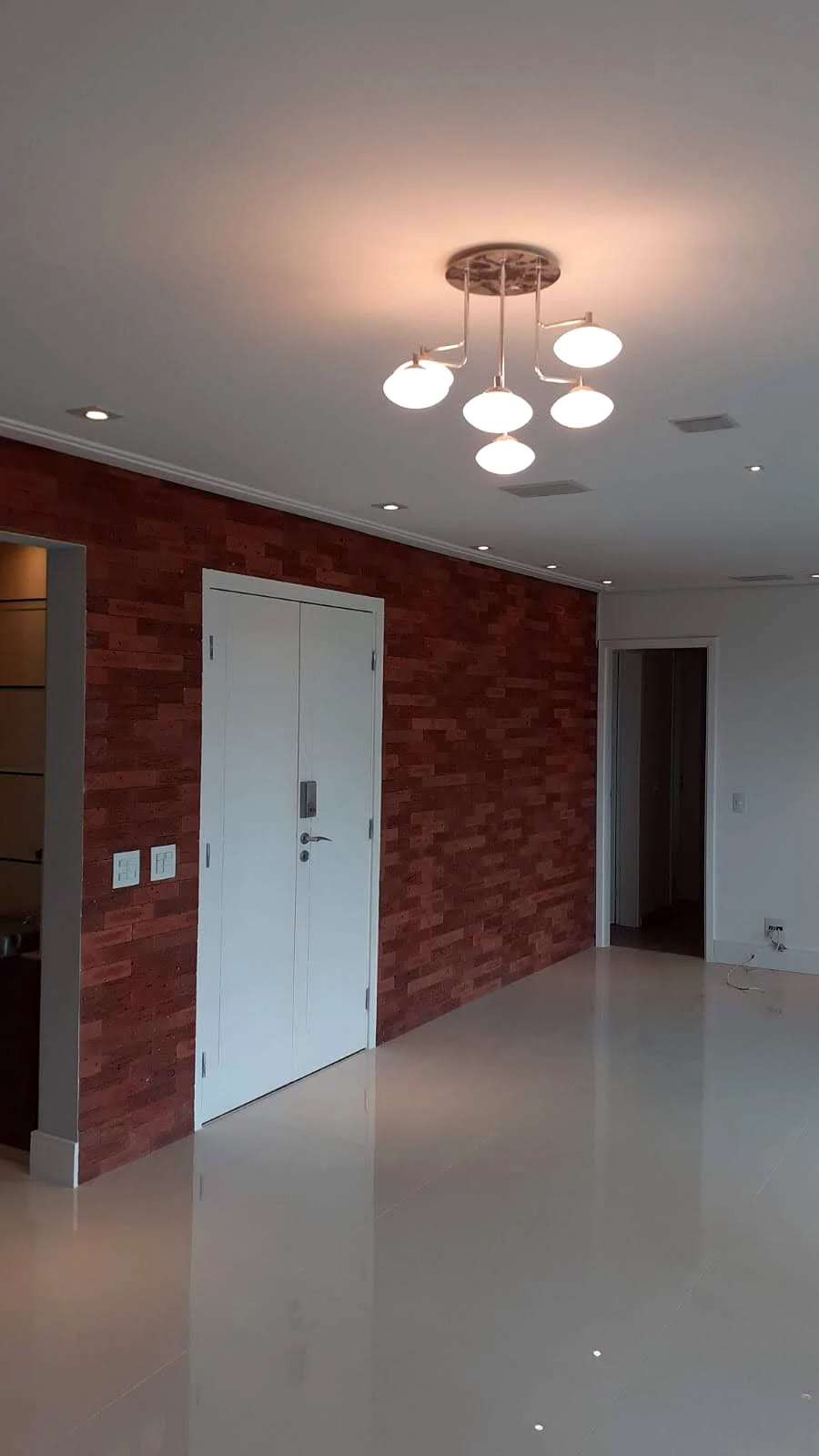 Sala com parede em tijolo aparente, obra executada pela FC Construção Civil